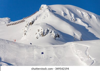 The Track Giant Slalom On The Background Of Snow-capped Mountains In The Bright Sun.