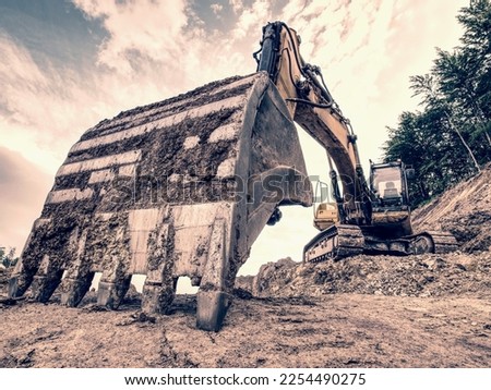 Track type loader is mining stones in opencast mining quarry. Heavy machinery in the open pit, excavators, dozers and trucks. Digging and excavation operations