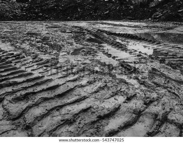 Tracked excavator track\
trail in the mud.