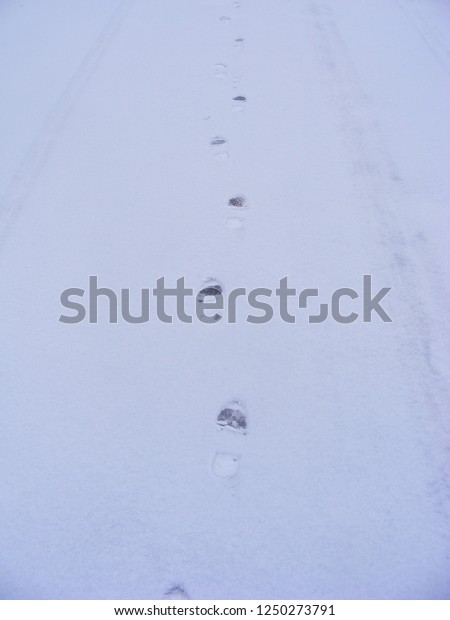 tracks of boots\
on snow close up vertical\
photo