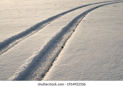 the tracks of a car through the snow