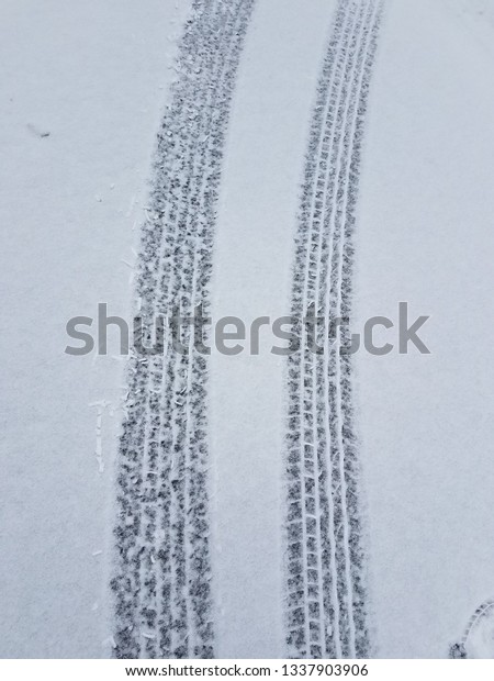  Tracks\
of car tires in thin layer of first snow\
