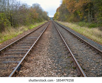 The Tracks Of Two Railway Lines Converge Into The Distance On An Autumn Day. Taken On Wirral In The North West Of The UK.