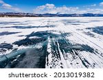 Tracks of winter road on frozen icy surface of Lake Laberge in boreal forest taiga landscape of Yukon Territory, YT, Canada