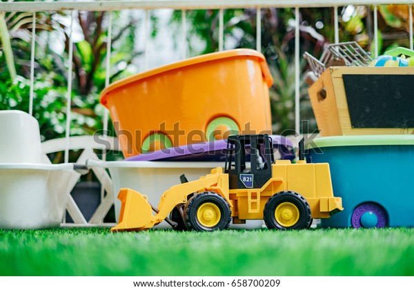 Tracktor toy car\
with toy boxes in the\
garden.