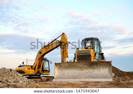 Track-type bulldozer, earth-moving equipment. Land clearing, grading, pool excavation, utility trenching, utility trenching and foundation digging during of large construction jobs. 