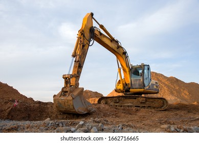 Track-type excavator during earthmoving work at open-pit mining. Loader machine with bucket in sand quarry. Backhoe digging the ground for the foundation and for laying sewer pipes district heating