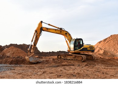 Track-type excavator during earthmoving works at open-pit mining. Heavy Construction Equipment Machines in Action. Digger during roadwork at construction site.
