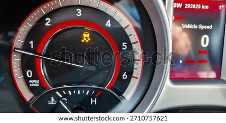 The traction control system warning light on the dashboard when driving on a slippery road. Dangers of driving a car during the winter season.