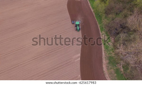 tractor - aerial view of a\
tractor at work - cultivating a field in spring - agricultural\
machinery