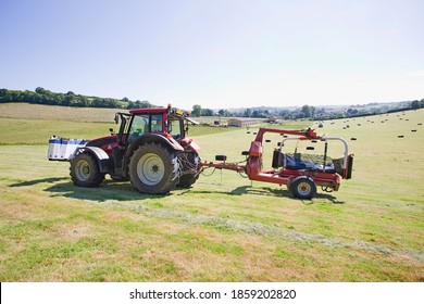 Tractor And Bale Wrapper Wrapping Bales Of Hay In The Field