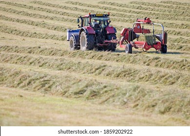 Tractor And Bale Wrapper Wrapping Bales Of Hay In Field