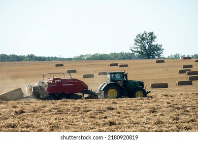 Tractor And Baler Twine On The Harvested Field