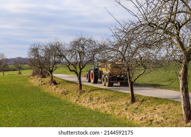 A Tractor With Big Trailer On A Country Road In Good Weather