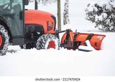 Tractor Cleaning Urban Park Paths On A Cold Snowy Day.