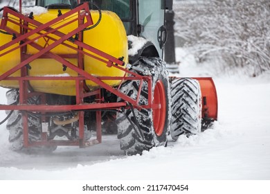 Tractor Cleaning Urban Park Paths On A Cold Snowy Day.