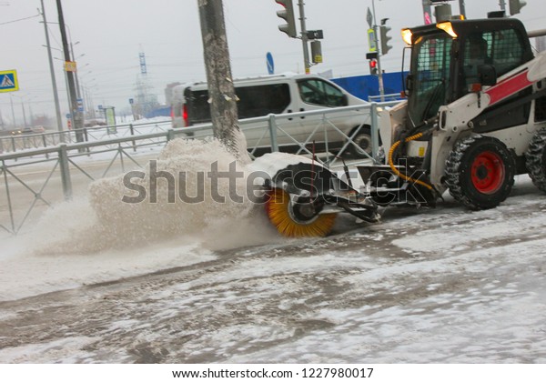 Tractor cleans snow\
brush