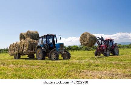 Tractor Collecting Hay Bales In The Fields