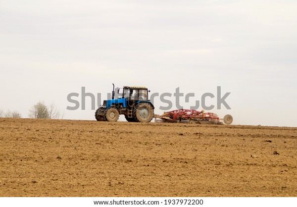 The tractor\
cultivates the soil in the\
spring