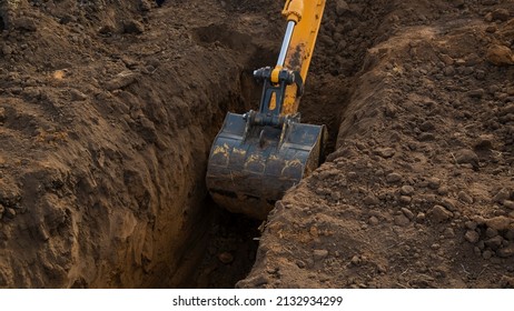 Tractor Digs a Trench, excavator bucket close-up.
