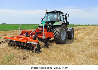 Tractor with a disc harrow on the farmland - Shutterstock ID 281879489