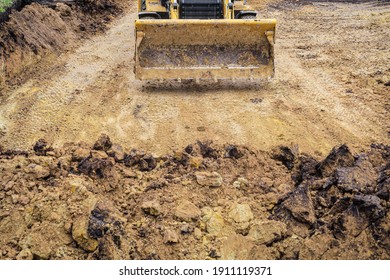 Tractor With Dozer Blade For Earthmoving Works In Construction Site Pit. Front View.