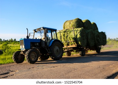 tractor driven hay rolled after seasonal harvesting