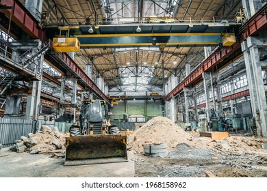 Tractor or excavator with bucket in large industrial workshop at factory, heavy industry concept - Powered by Shutterstock