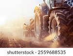 tractor in the field pulls plough or cultivator to loosen the soil and prepare it for sowing in bright sunshine
