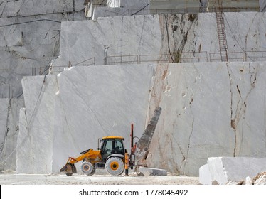 Tractor with a giant saw used for cutting marble blocks. Carrara marble quarry, extraction and processing of white marble. Open mining. 