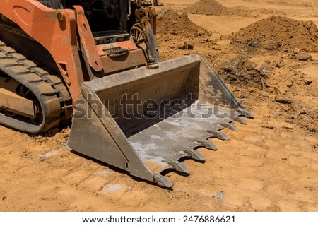 Tractor is leveling ground at construction project in backyard