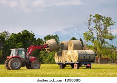 Tractor Lifting Hay Bale On Barrow