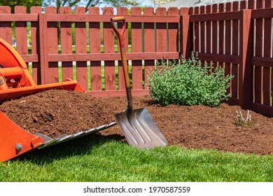 Tractor Loader With Wood Chips Or Mulch And Flowerbed. Lawncare, Gardening And Backyard Landscaping Concept