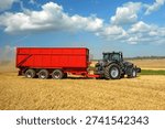 Tractor with loading wagon in a stubble field during the grain harvest - 0329