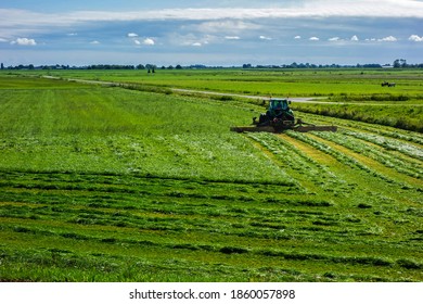 Tractor Mowing Grass In A Meadow
