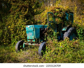 Tractor. Old rusty abandoned tractor overgrown with vines. - Shutterstock ID 2255124709