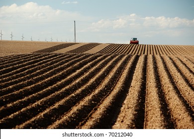 A Tractor Planting A Farm Field In The Spring.