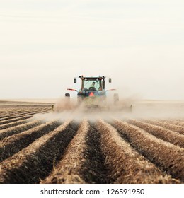 A tractor planting a potato crop on the prairies.