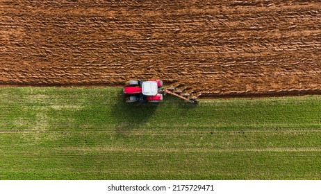 Tractor ploughing a meadow of grass in aerial view. Land preparation before cultivation - Powered by Shutterstock