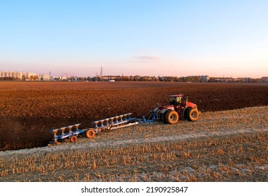 Tractor Plowing Field On Sunset. Cultivated And Soil Tillage. Tractor On Land Cultivating. Agricultural Tractor On Cultivation Field. Tractor Disk Harrow On Plowing Field. Winter Wheat Planting.