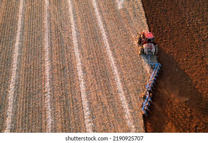 Tractor Plowing Field, Top View. Cultivated And Soil Tillage. Tractor On Land Cultivating. Agricultural Tractor On Cultivation Field. Tractor Disk Harrow On Plowing Field. Winter Wheat Planting.