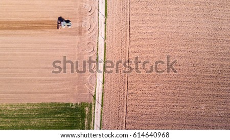 Similar – A combine harvester is harvesting grain crops on a cornfield in the evening sun seen from above