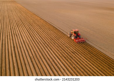 Tractor prepares soil for cultivation dragging plow behind on endless field. Powerful machine works in agriculture at rural site aerial view - Powered by Shutterstock