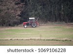 Tractor pull log on field with forest