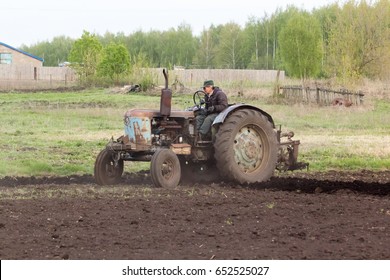 Tractor pulling a plow plowing a field.