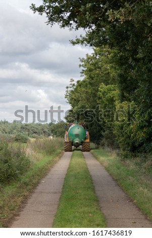 A tractor pulling a slurry tanker back to the farm
