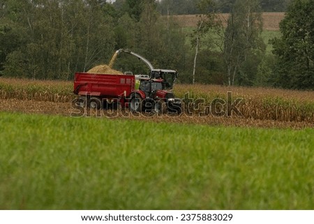The tractor pulls the siding, which the combine fills with corn.