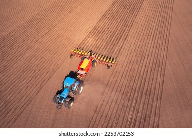 A tractor with a seeder on the field drone view, the spring season of the sowing campaign. - Powered by Shutterstock