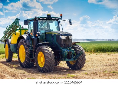 tractor with sprayer trailer beside the cereal field