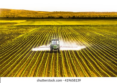 Tractor spraying a field of corn